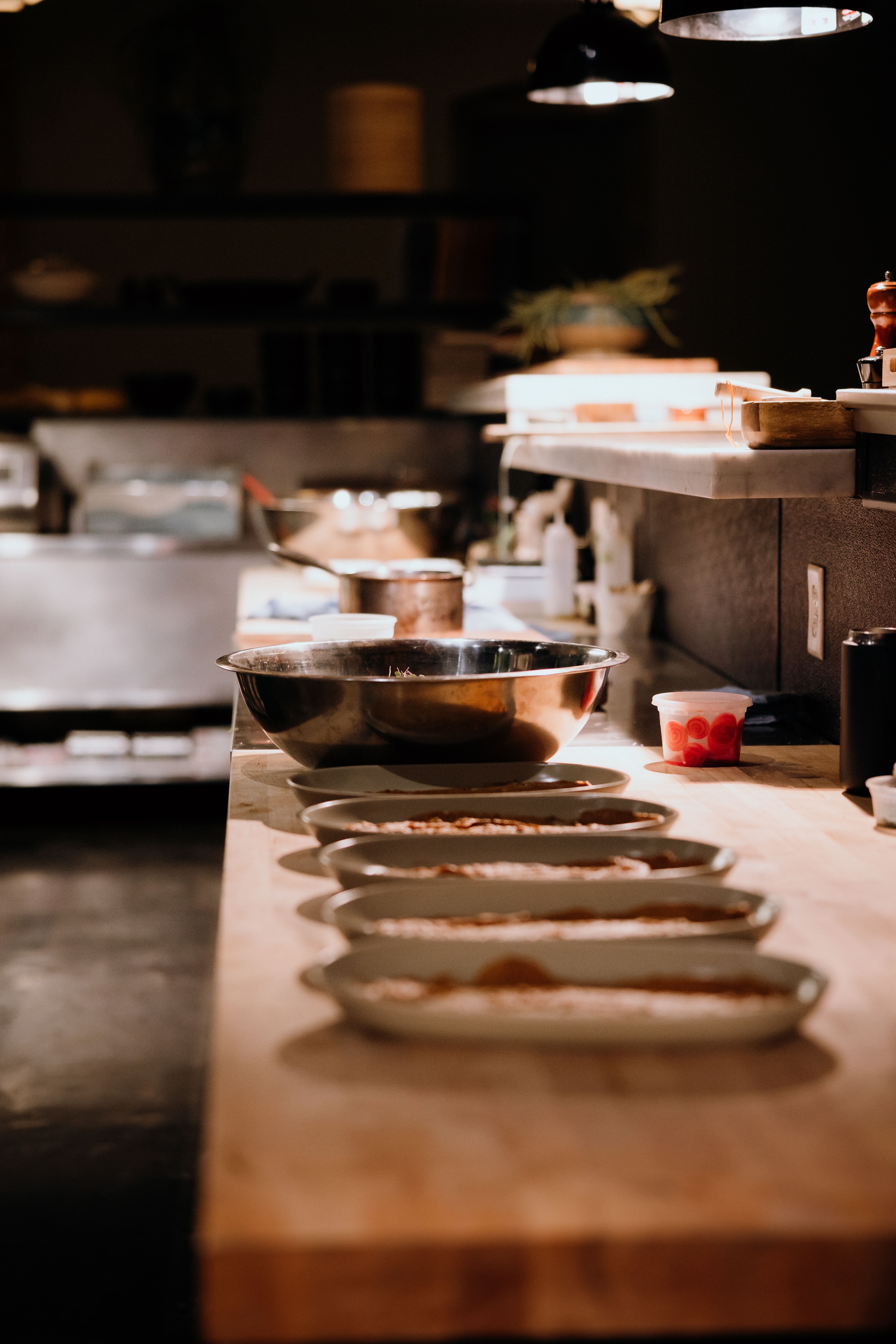 A quiet kitchen pass with plates and prep laid out, the work behind the door the guest never sees.