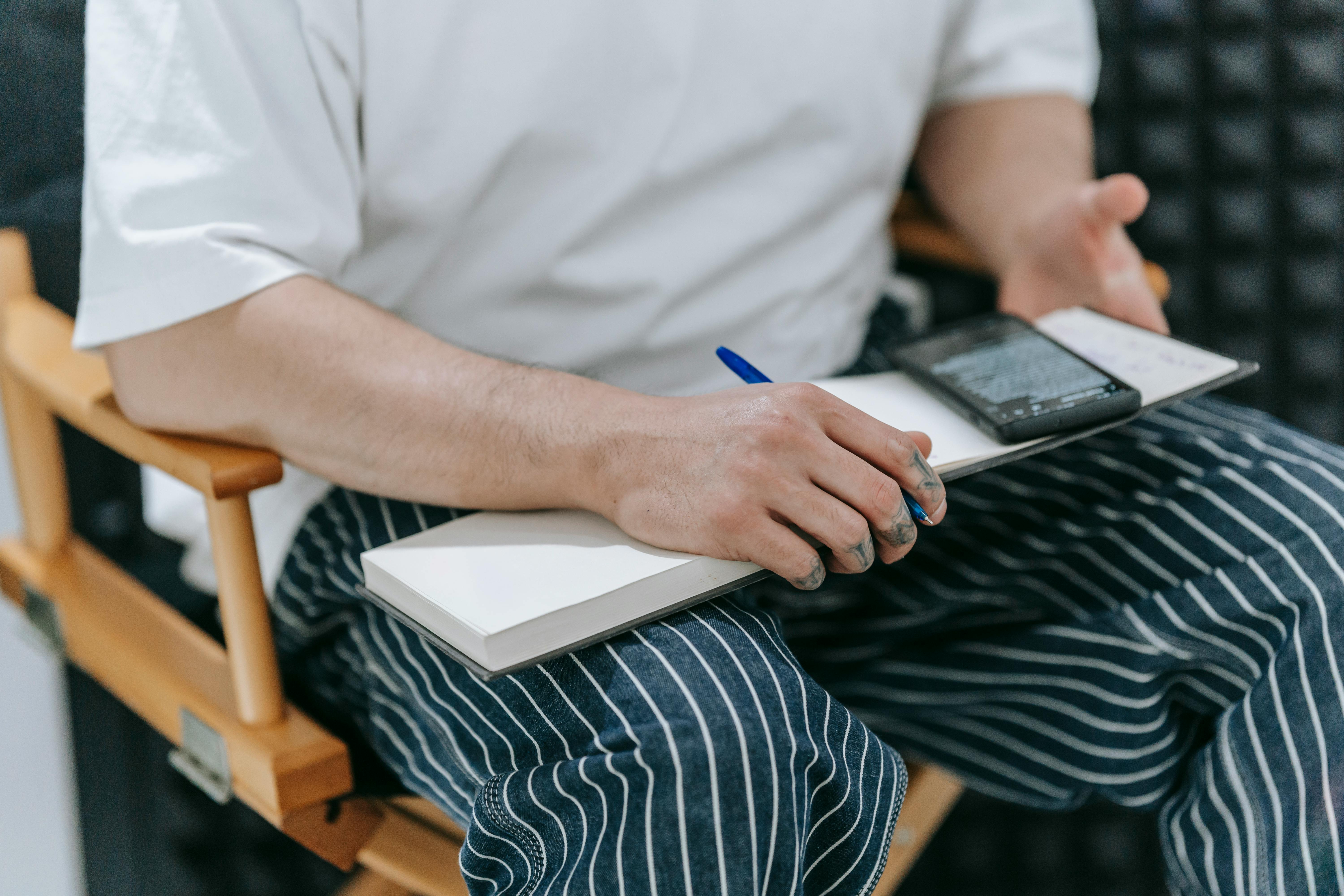A chef in an apron writing in a notebook, the kind of note that usually stays in someone's head.